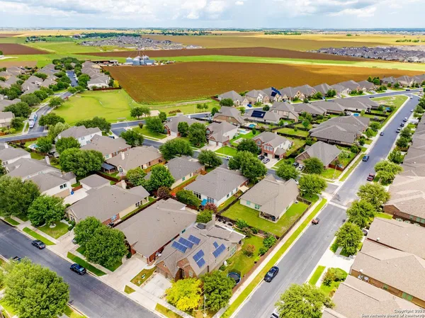 an aerial view of ocean and residential houses with outdoor space