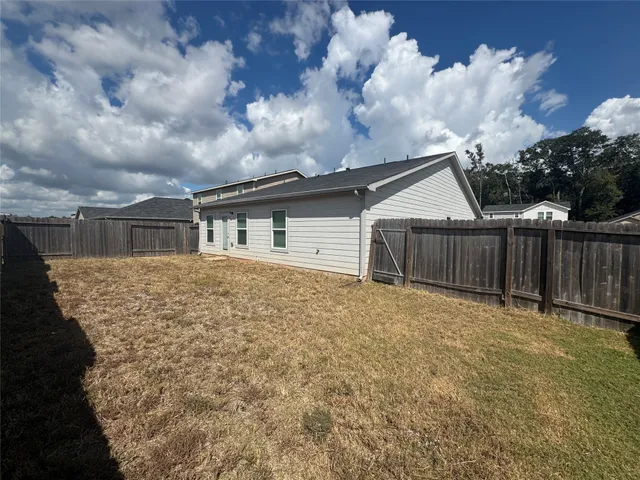 view of house with yard and wooden fence