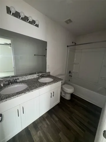 a bathroom with a granite countertop sink a toilet and shower