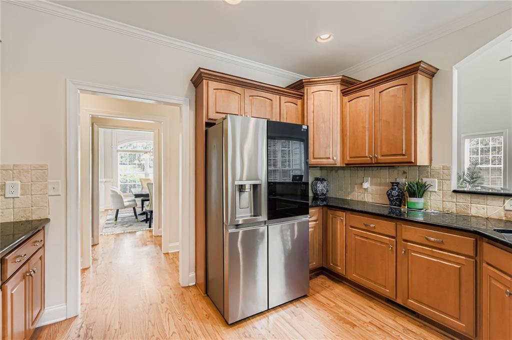 7641 Capps Ridge Lane Douglasville, GA 30135 - Photo 5 of 26 a kitchen with stainless steel appliances granite countertop a refrigerator a sink and wooden cabinets