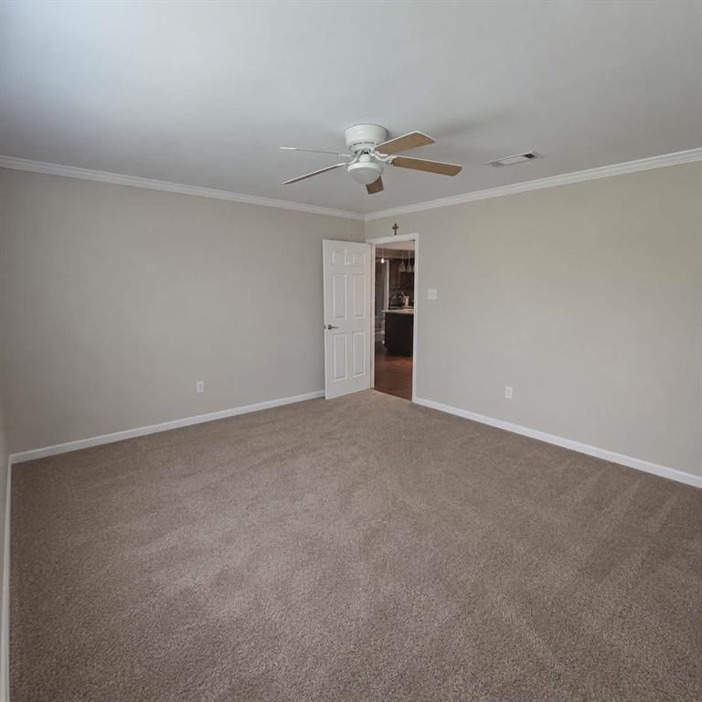 14752 Ranch Road Forney, TX 75126 - Photo 15 of 40 Spacious room featuring neutral carpeting, light-toned wall paint, crisp white trim, and a ceiling fan with wood-finish blades-This photo was taken before family moved in