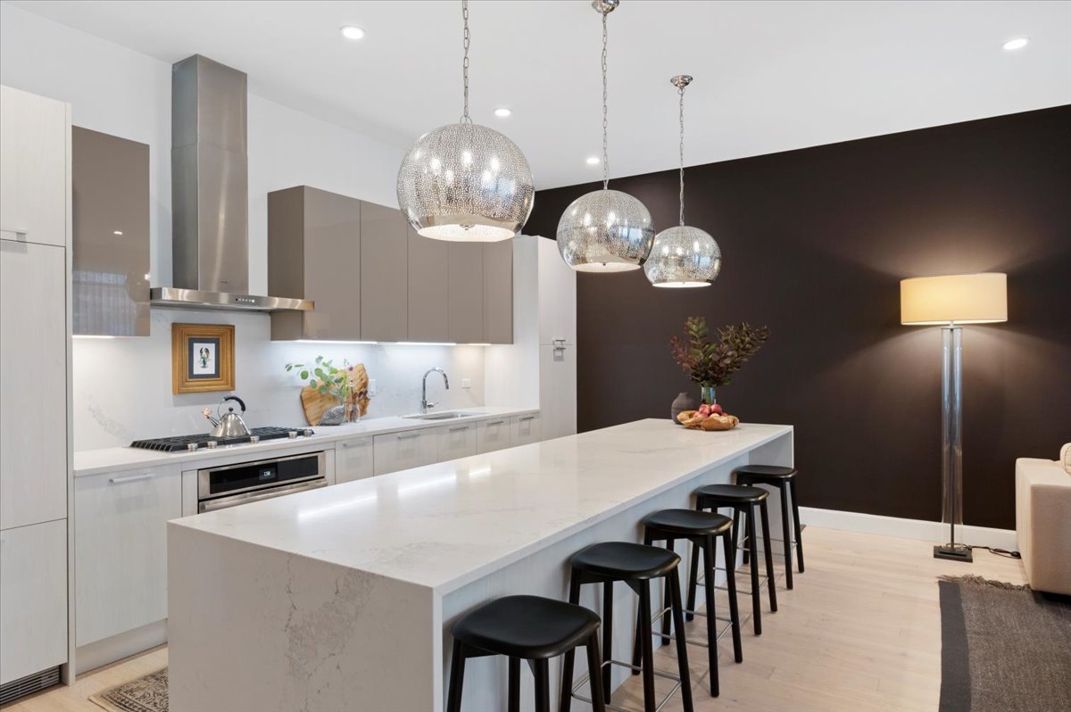 36 North Carpenter Street, Unit 2N Chicago, IL 60607 - Photo 12 of 26 a kitchen with stainless steel appliances a table chairs and chandelier