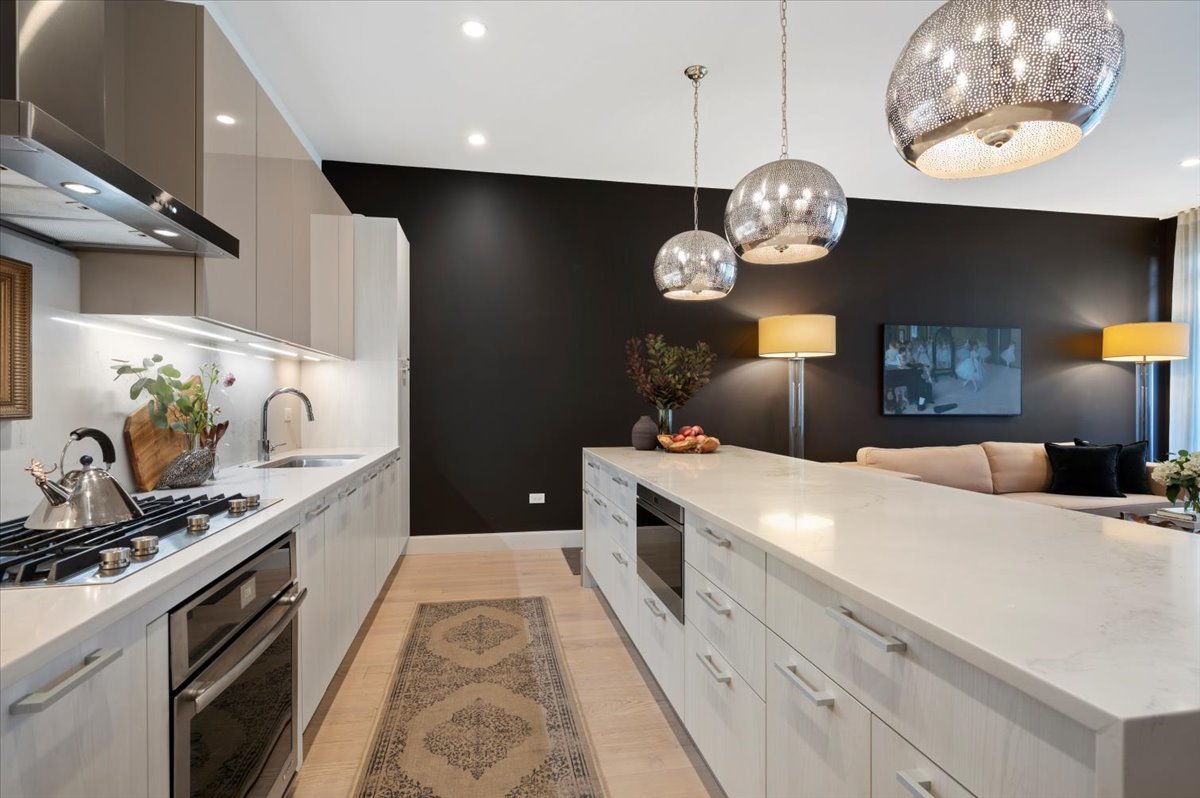 36 North Carpenter Street, Unit 2N Chicago, IL 60607 - Photo 13 of 26 a kitchen with a stove and a clock on the wall
