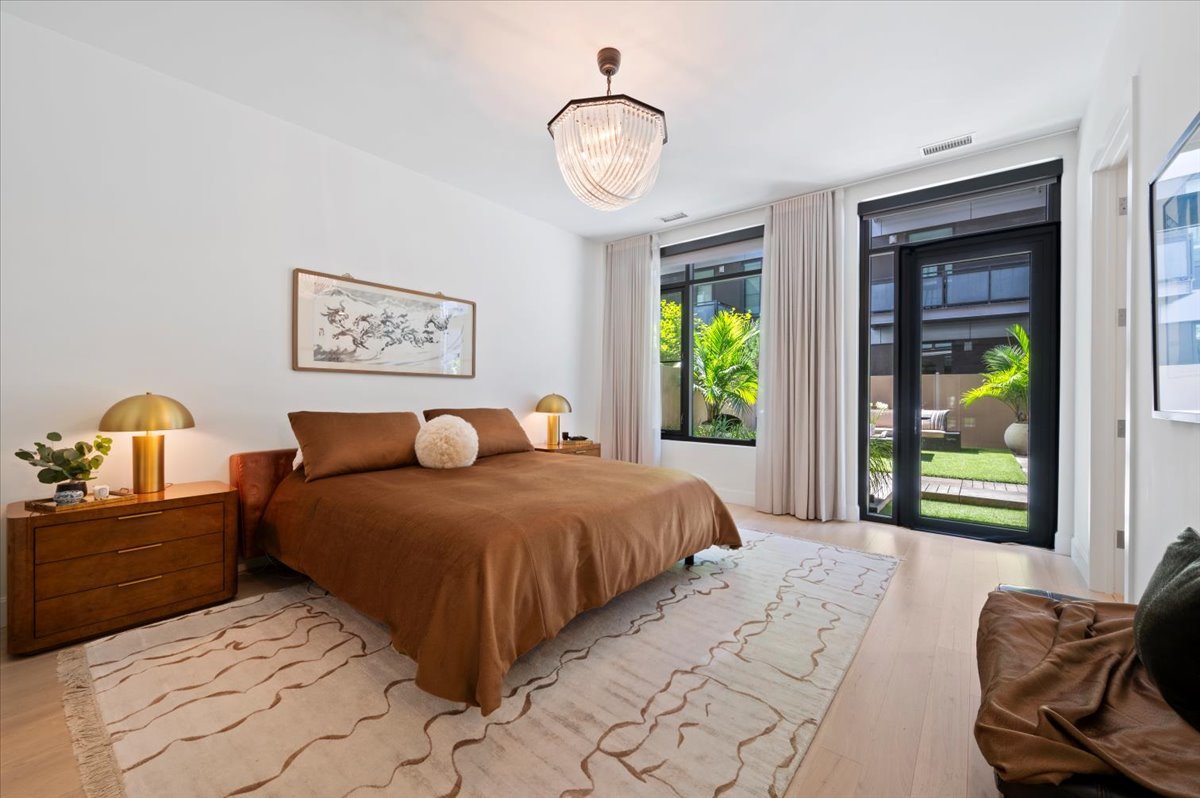 36 North Carpenter Street, Unit 2N Chicago, IL 60607 - Photo 15 of 26 a bedroom with a bed and a chandelier