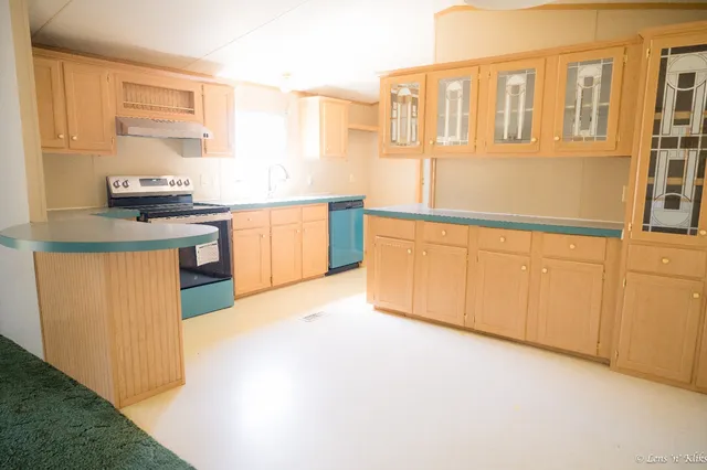 a kitchen with stainless steel appliances granite countertop a stove a sink and a microwave