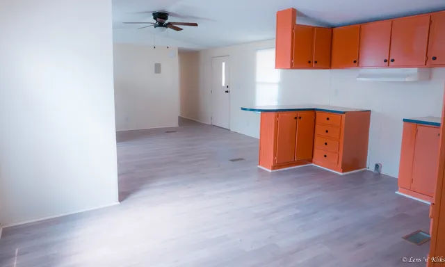 an empty room with windows & cabinet