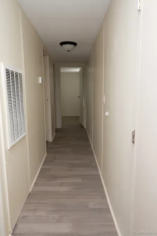 a view of a hallway with wooden floor