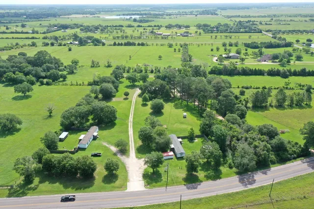 an aerial view of green landscape with trees houses and lake view