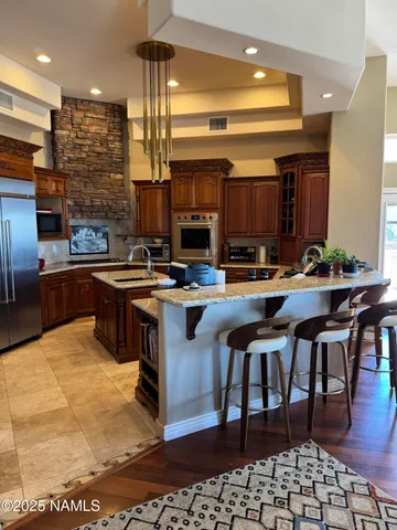 a kitchen with stainless steel appliances granite countertop a stove a sink and a microwave