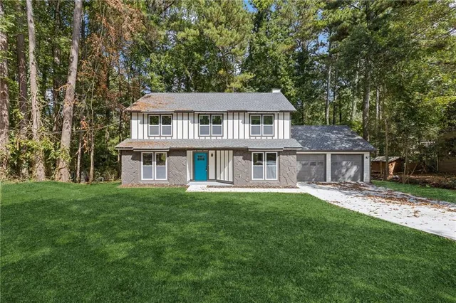 a view of a house with a big yard and potted plants