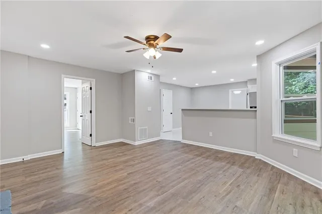 a view of an empty room with wooden floor