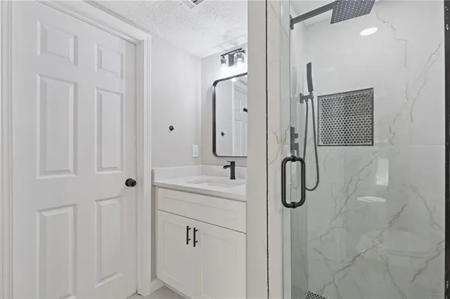 a bathroom with a shower sink and mirror