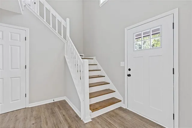 a view of staircase with wooden floor and white walls