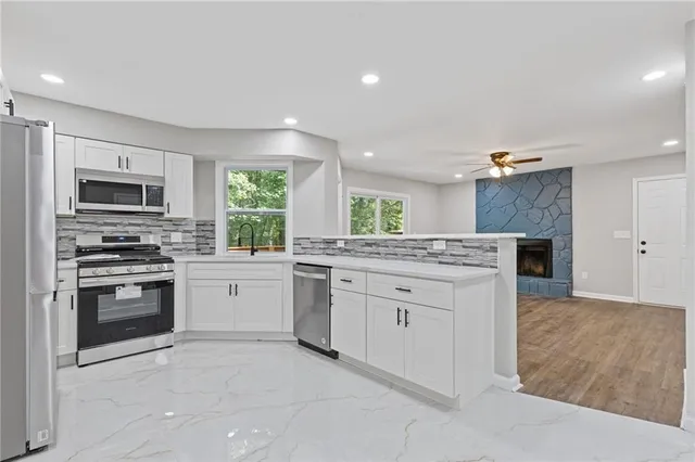 a kitchen with granite countertop a refrigerator and a stove top oven