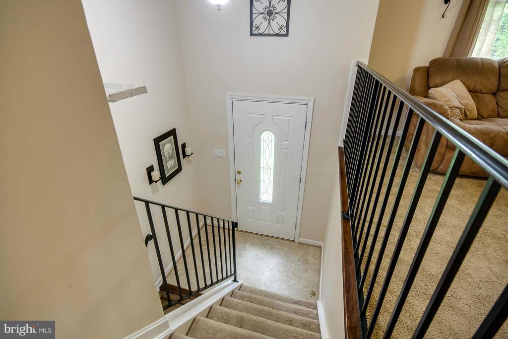 121 Plum Point Road Huntingtown, MD 20639 - Photo 2 of 30 a view of a hallway with wooden floor and stairs