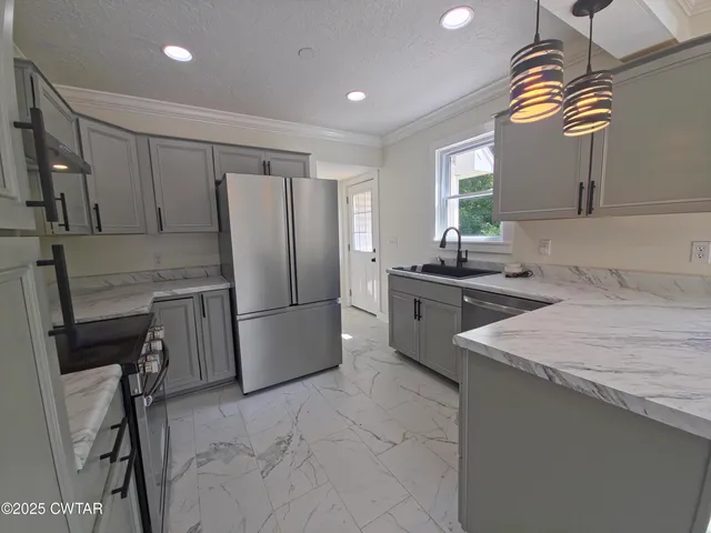 a kitchen with a sink appliances and cabinets