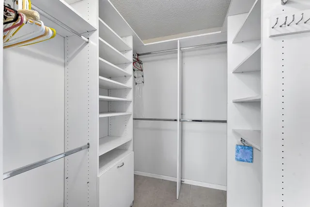 a view of walk in closet with empty racks