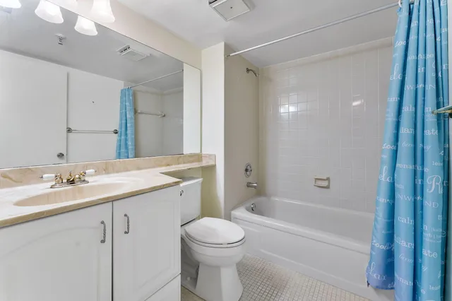 a bathroom with a granite countertop sink a toilet and shower