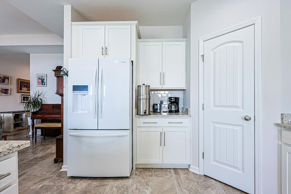 2821 Rivolet Drive Conway, SC 29526 - Photo 7 of 34 Kitchen featuring white fridge with ice dispenser, white cabinets, light stone countertops, and tasteful backsplash