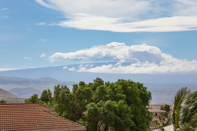 a front view of a house with a yard and mountain view