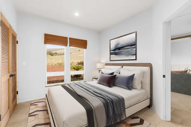 a bedroom with a large bed and a painting on the wall