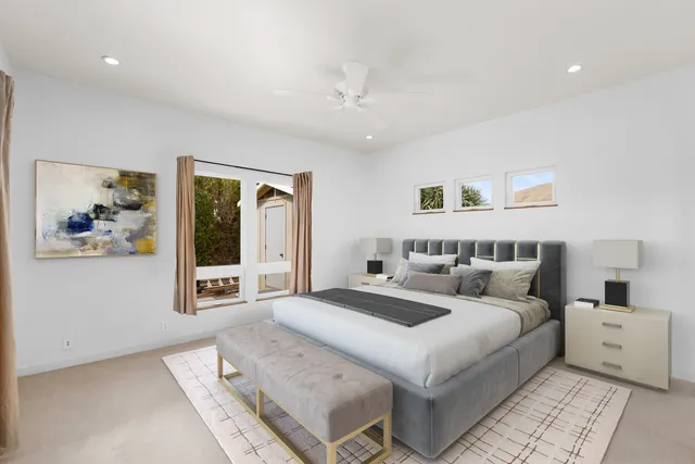 a bedroom with furniture and a large window