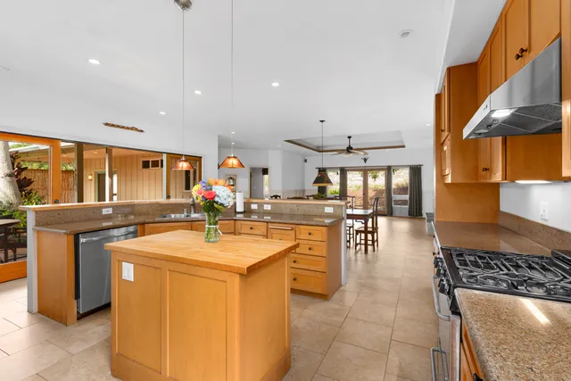 a kitchen with stainless steel appliances granite countertop a stove a sink and a refrigerator