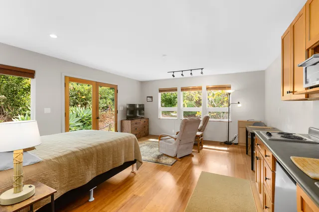 a bedroom with a bed a large window and chair