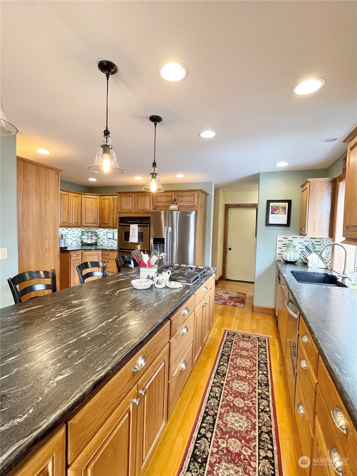 14 Pogue Road Okanogan, WA 98840 - Photo 13 of 40 a view of a kitchen with kitchen island stainless steel appliances a sink and a wooden floor