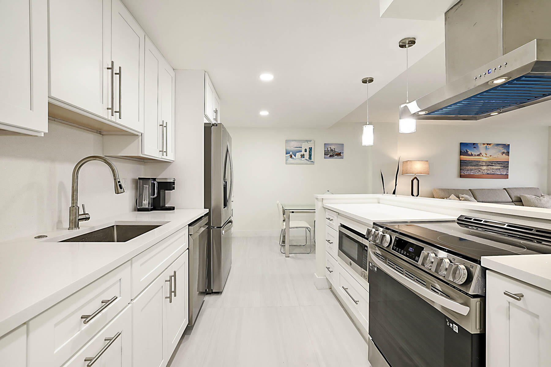 2121 North Ocean Boulevard, Unit 806W Boca Raton, FL 33431 - Photo 16 of 63 a kitchen with stainless steel appliances a sink stove and cabinets