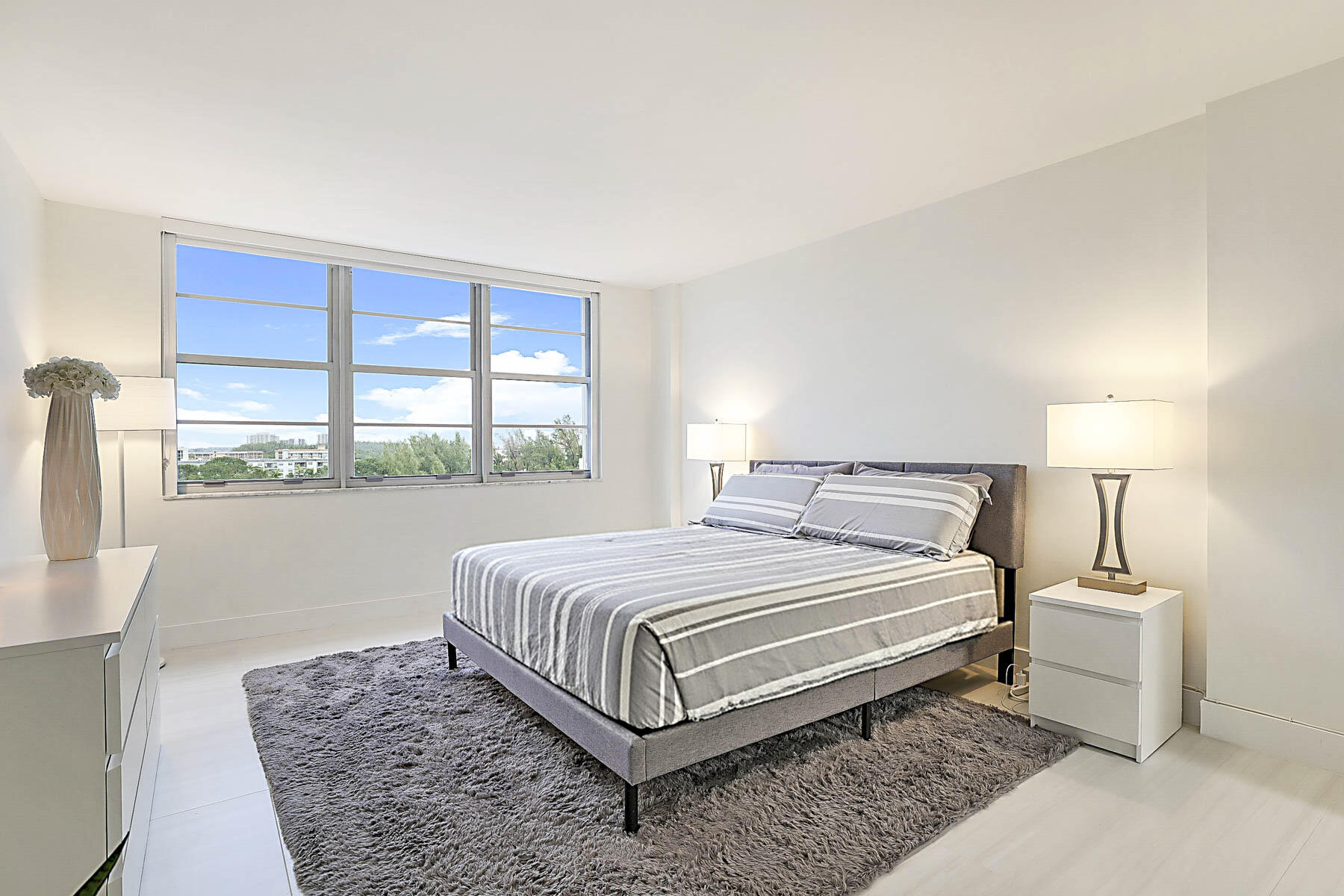 2121 North Ocean Boulevard, Unit 806W Boca Raton, FL 33431 - Photo 19 of 63 a bedroom with a bed lamp and window