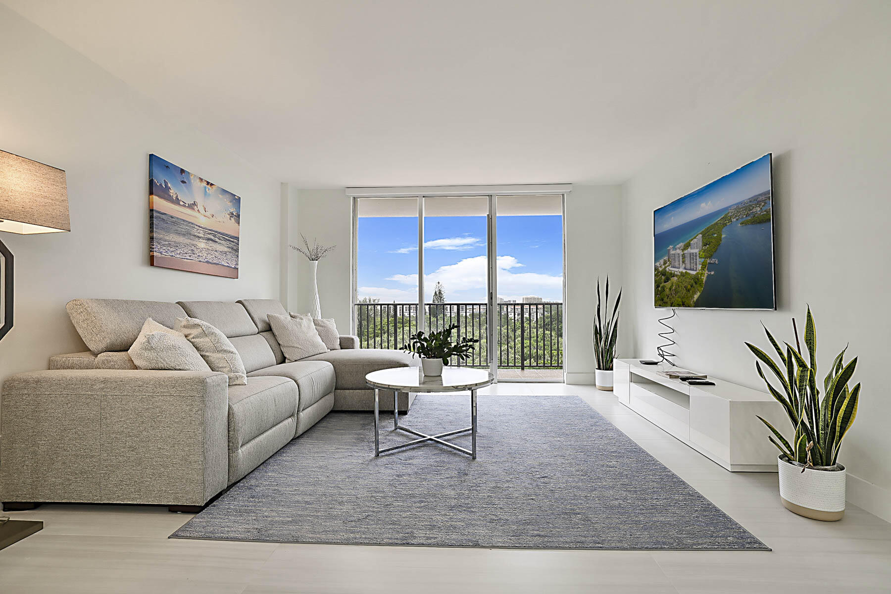2121 North Ocean Boulevard, Unit 806W Boca Raton, FL 33431 - Photo 5 of 63 a living room with furniture flat screen tv and a large window