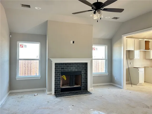 an empty room with windows and fireplace