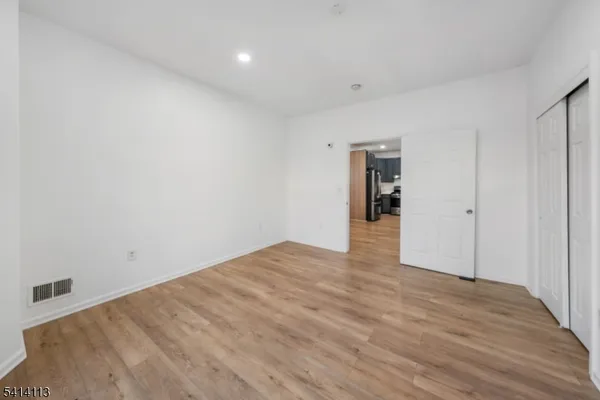 a view of an empty room with wooden floor