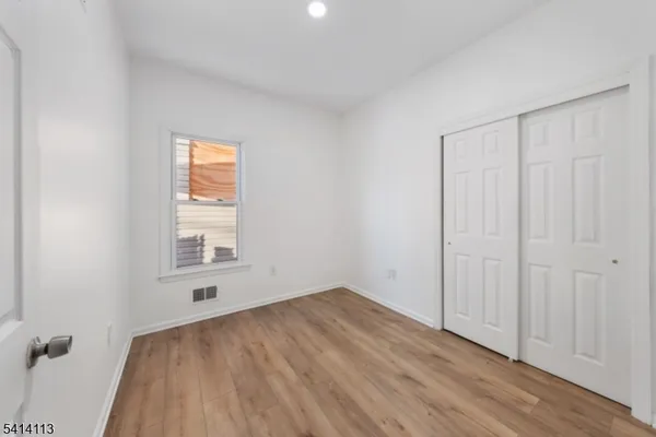 an empty room with a hardwood and windows