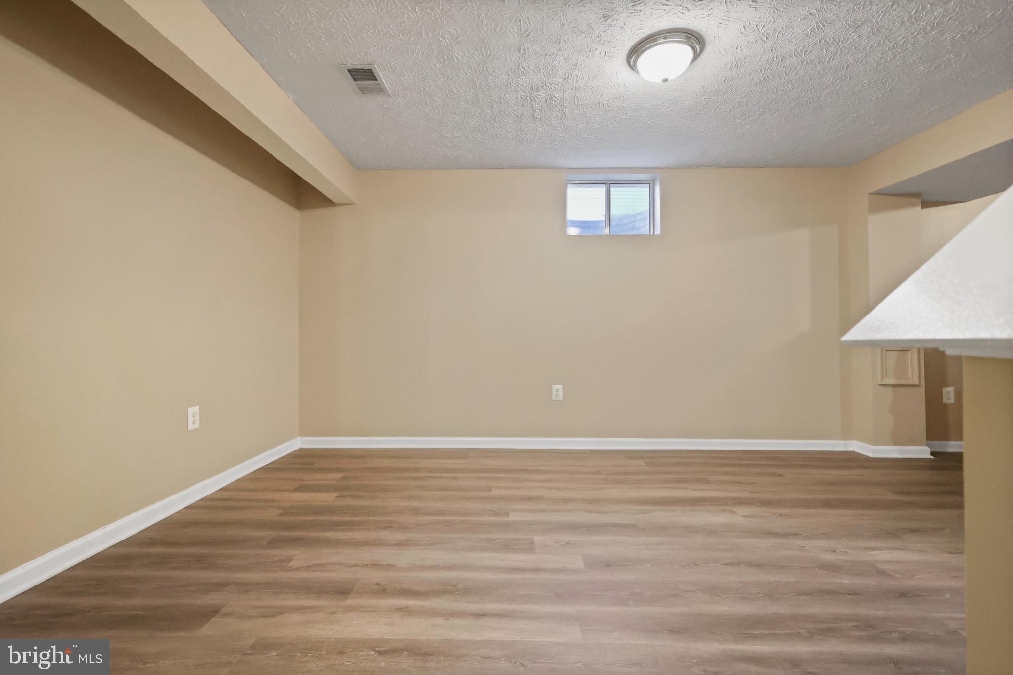 9716 Penguin Place Upper Marlboro, MD 20772 - Photo 49 of 84 a view of an empty room with wooden floor and a window