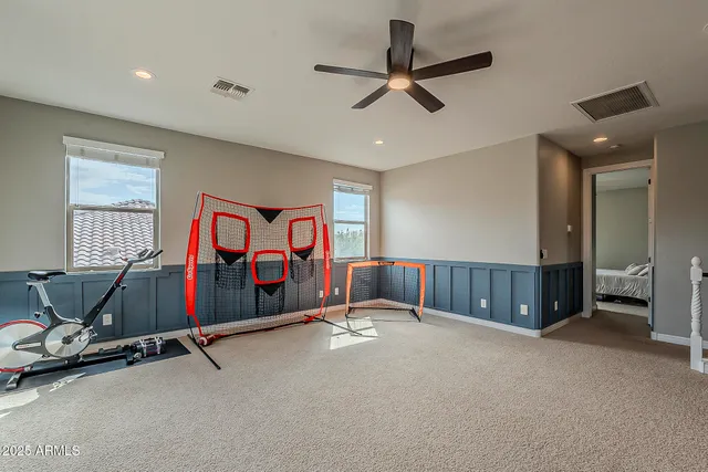 a bedroom with two beds and ceiling fan