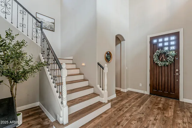 a dining room with wooden floor a chandelier a wooden table and chairs