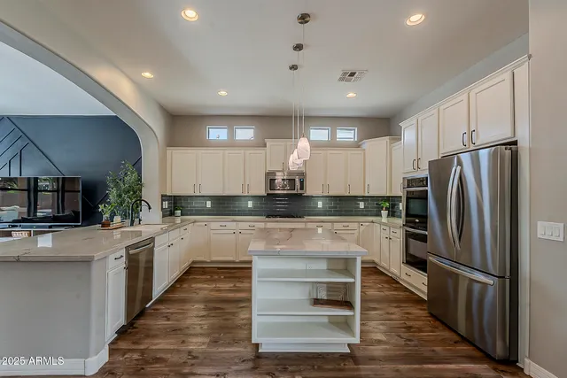 a kitchen with a stove a refrigerator and a dining table with wooden floor