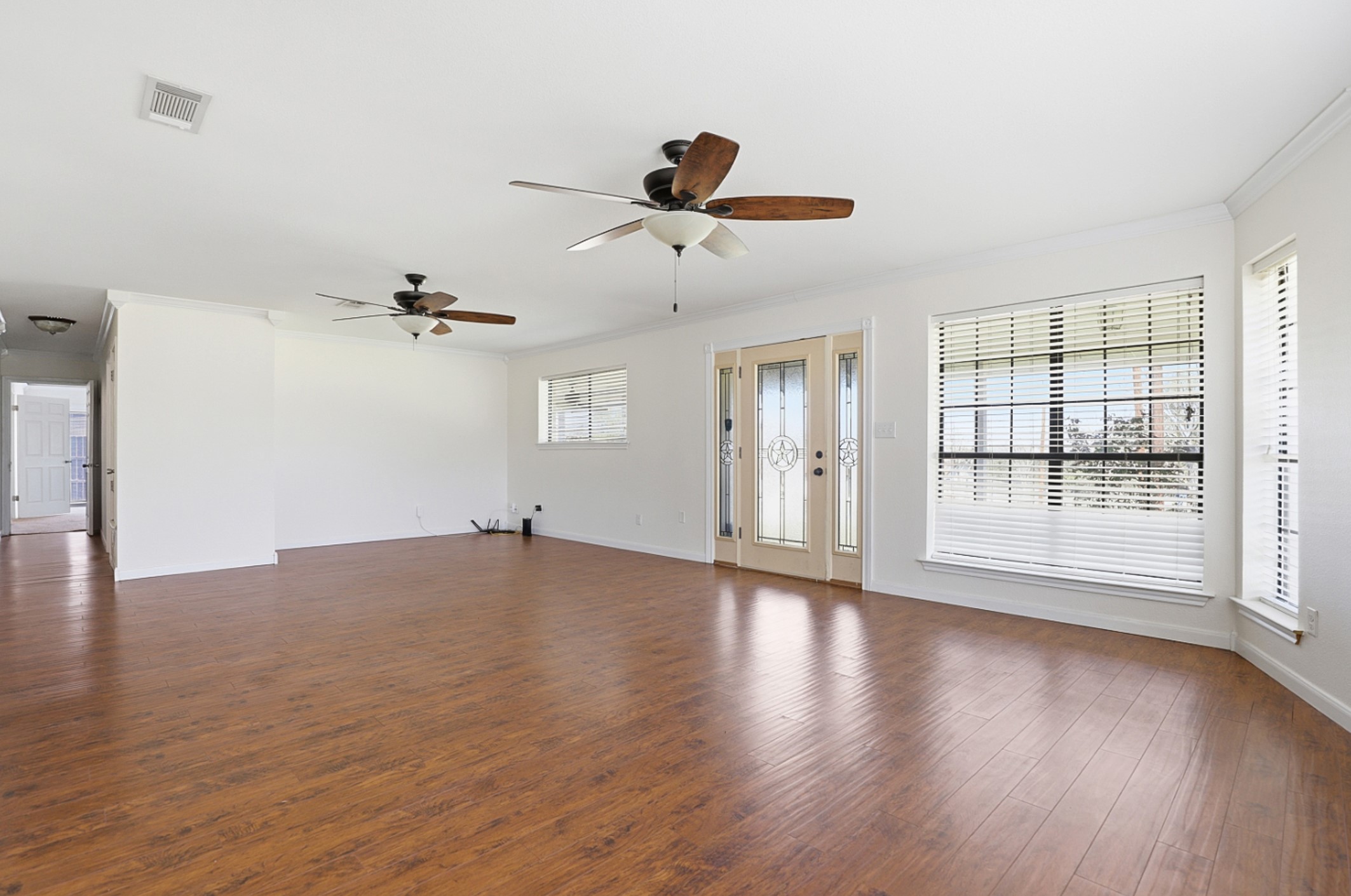 128 Skyview Terrace Leander, TX 78641 - Photo 3 of 23 Unfurnished living room featuring dark wood-style floors, crown molding, and a ceiling fan