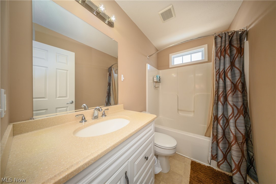 4431 7th Street Northwest Canton, OH 44708 - Photo 13 of 23 Bathroom with shower / bathtub combination with curtain, vanity, and light tile patterned flooring