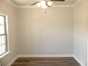 a view of small space with wooden floor and fan