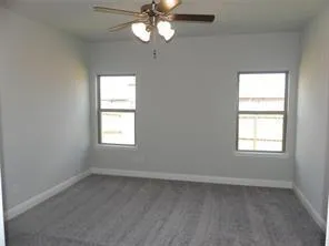 an empty room with a window and a fan