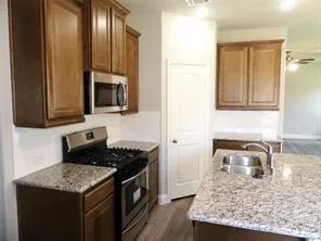 a kitchen with stainless steel appliances granite countertop a sink stove and cabinets
