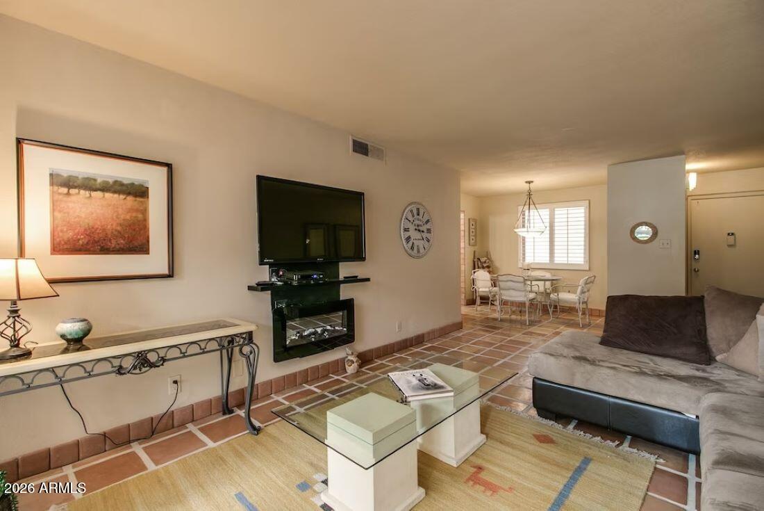 7625 East Camelback Road, Unit B117 Scottsdale, AZ 85251 - Photo 1 of 27 a living room with furniture and a flat screen tv