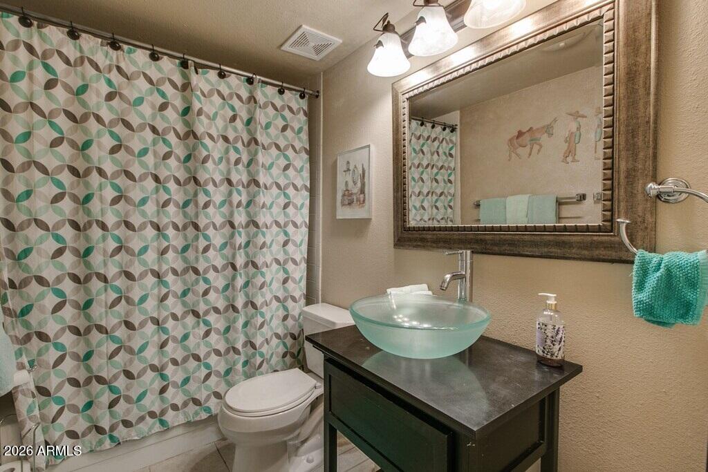 7625 East Camelback Road, Unit B117 Scottsdale, AZ 85251 - Photo 15 of 27 a bathroom with a sink toilet and mirror