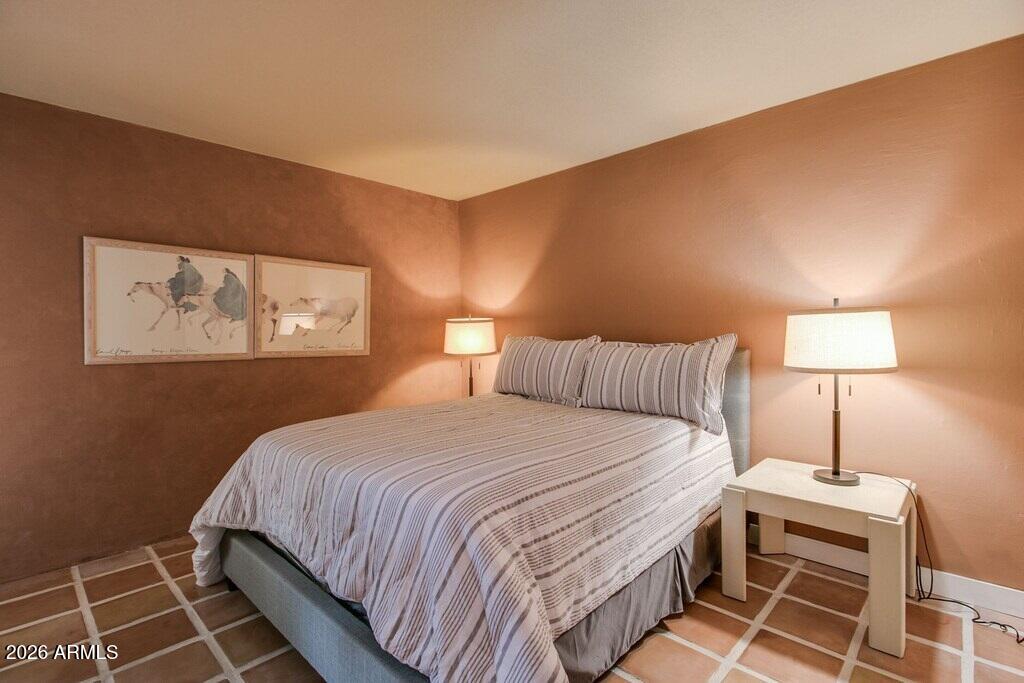 7625 East Camelback Road, Unit B117 Scottsdale, AZ 85251 - Photo 16 of 27 a bedroom with a bed and a lamp on dresser