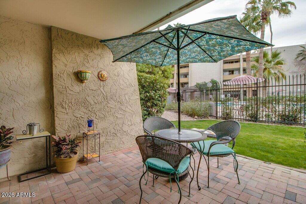 7625 East Camelback Road, Unit B117 Scottsdale, AZ 85251 - Photo 20 of 27 a patio with a yard table and chairs