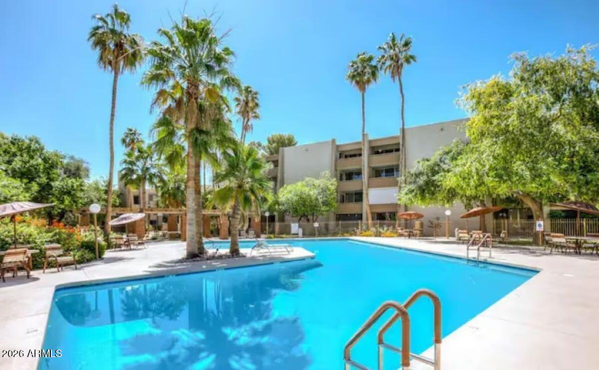 7625 East Camelback Road, Unit B117 Scottsdale, AZ 85251 - Photo 2 of 27 a swimming pool with outdoor seating and yard