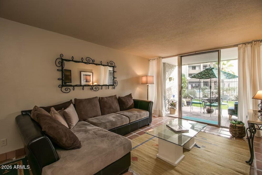 7625 East Camelback Road, Unit B117 Scottsdale, AZ 85251 - Photo 3 of 27 a living room with furniture and a floor to ceiling window